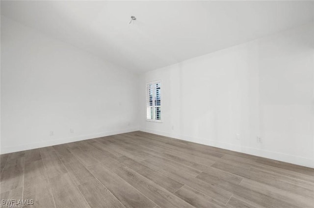 16131 Kelly Woods Dr, Fort Myers, FL 33908 - spare room featuring wood finished floors and lofted ceiling