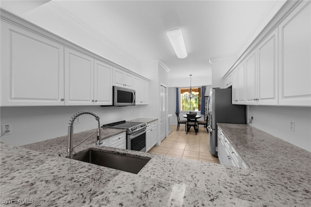 8550 Kingbird Loop Unit 629, Estero, FL 33967 - kitchen featuring appliances with stainless steel finishes, light stone counters, white cabinets, hanging light fixtures, and crown molding