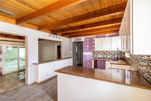 208 Flamingo St, Fort Myers Beach, FL 33931 - kitchen with a wood ceiling with exposed beams, white cabinetry, decorative backsplash, dark stone counters, and a peninsula