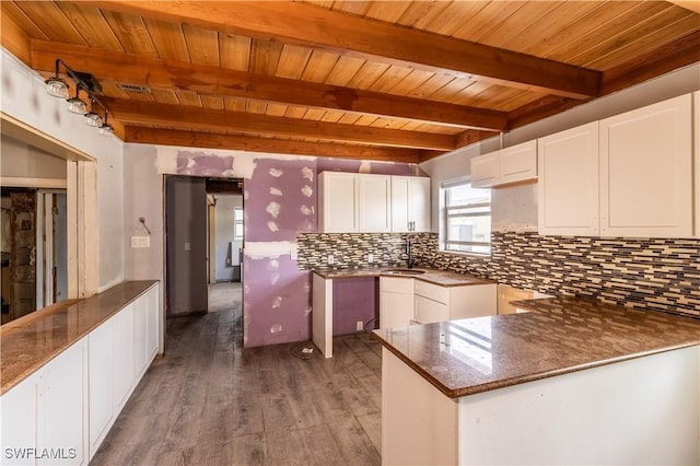 208 Flamingo St, Fort Myers Beach, FL 33931 - kitchen with a wooden ceiling with exposed beams, wood finished floors, backsplash, white cabinets, and a peninsula