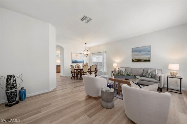 9795 Gladiolus Bulb Loop, Fort Myers, FL 33908 - living room featuring arched walkways, light wood-style floors, and a chandelier