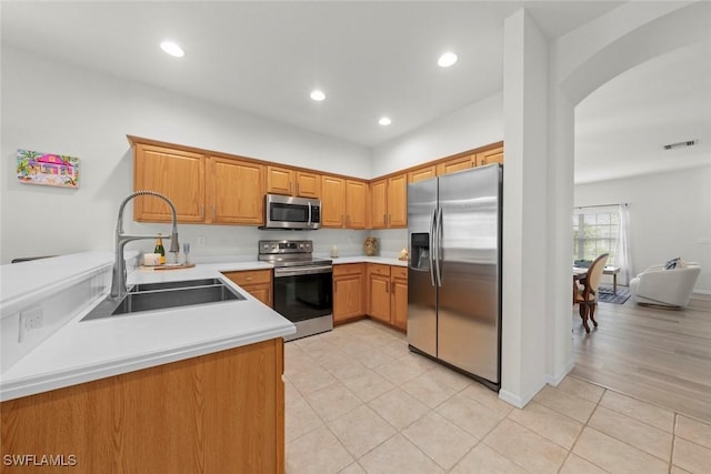 9795 Gladiolus Bulb Loop, Fort Myers, FL 33908 - kitchen featuring stainless steel appliances, light tile patterned flooring, arched walkways, light countertops, and recessed lighting