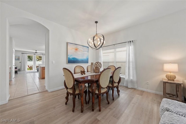 9795 Gladiolus Bulb Loop, Fort Myers, FL 33908 - dining space featuring arched walkways, light wood-type flooring, and a chandelier