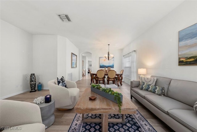 9795 Gladiolus Bulb Loop, Fort Myers, FL 33908 - living room featuring arched walkways, light wood-type flooring, and a chandelier