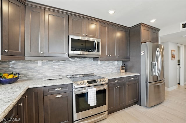 7148 Estero Blvd Unit 922, Fort Myers Beach, FL 33931 - kitchen with appliances with stainless steel finishes, dark brown cabinets, decorative backsplash, recessed lighting, and light stone countertops