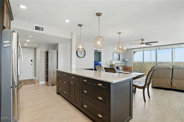 7148 Estero Blvd Unit 922, Fort Myers Beach, FL 33931 - kitchen with freestanding refrigerator, open floor plan, a ceiling fan, light stone counters, and decorative light fixtures