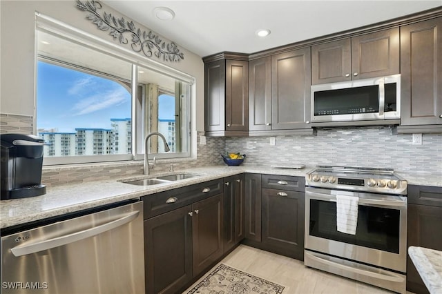 7148 Estero Blvd Unit 922, Fort Myers Beach, FL 33931 - kitchen featuring stainless steel appliances, dark brown cabinetry, decorative backsplash, and light stone countertops