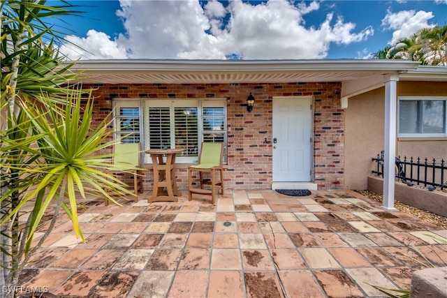 225 SW 43rd Ln, Cape Coral, FL 33914 - view of exterior entry with brick siding, a patio area, and stucco siding