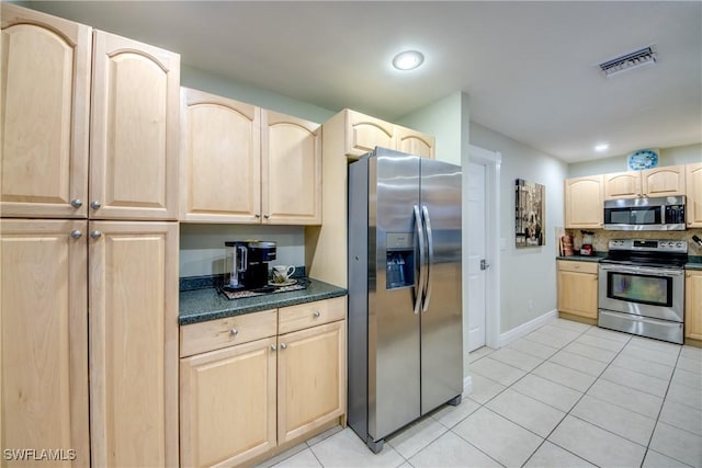 225 SW 43rd Ln, Cape Coral, FL 33914 - kitchen with stainless steel appliances, light brown cabinets, dark countertops, light tile patterned flooring, and tasteful backsplash