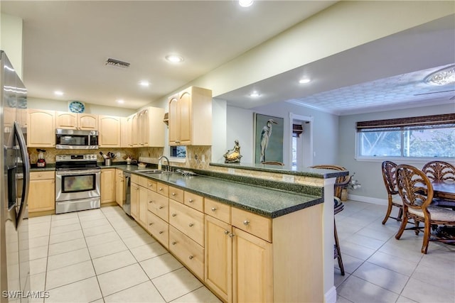 225 SW 43rd Ln, Cape Coral, FL 33914 - kitchen featuring stainless steel appliances, light brown cabinetry, light tile patterned flooring, a peninsula, and a kitchen bar