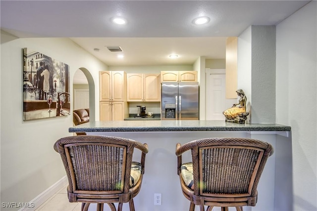225 SW 43rd Ln, Cape Coral, FL 33914 - kitchen featuring stainless steel refrigerator with ice dispenser, a peninsula, recessed lighting, a kitchen breakfast bar, and arched walkways