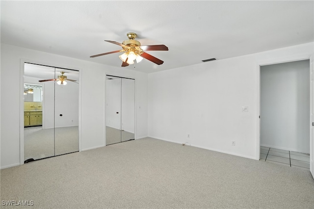 131 Bay Mar Dr, Fort Myers Beach, FL 33931 - unfurnished bedroom with carpet, multiple closets, and a ceiling fan