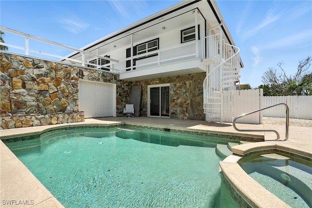 131 Bay Mar Dr, Fort Myers Beach, FL 33931 - back of property featuring stairs, stone siding, a patio area, a pool with connected hot tub, and a balcony