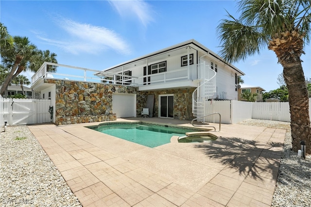131 Bay Mar Dr, Fort Myers Beach, FL 33931 - back of property with a gate, a patio area, stairs, stone siding, and a pool with connected hot tub