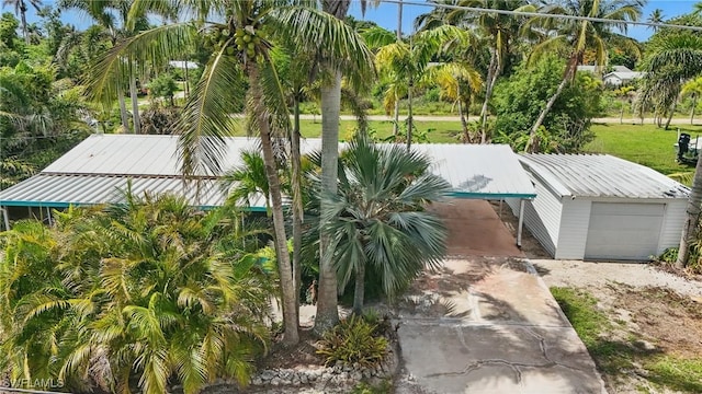 7434 Cares Away Park Cir, Bokeelia, FL 33922 - view of front of property with concrete driveway, a metal roof, an outbuilding, and a carport