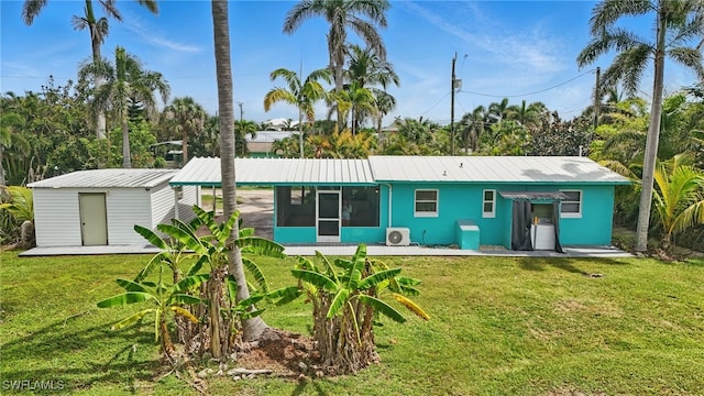 7434 Cares Away Park Cir, Bokeelia, FL 33922 - rear view of house with a sunroom, a yard, a storage unit, and a metal roof