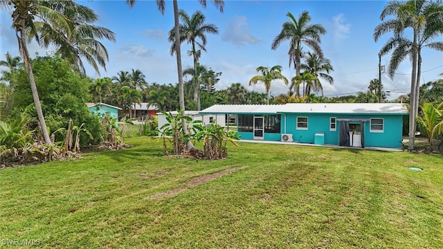 7434 Cares Away Park Cir, Bokeelia, FL 33922 - rear view of property with a lawn and a sunroom