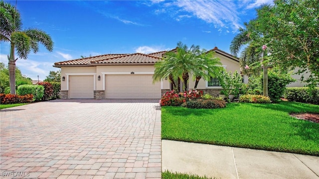 3668 Treasure Cove Ct, Naples, FL 34114 - mediterranean / spanish-style home featuring stucco siding, decorative driveway, stone siding, a garage, and a front yard