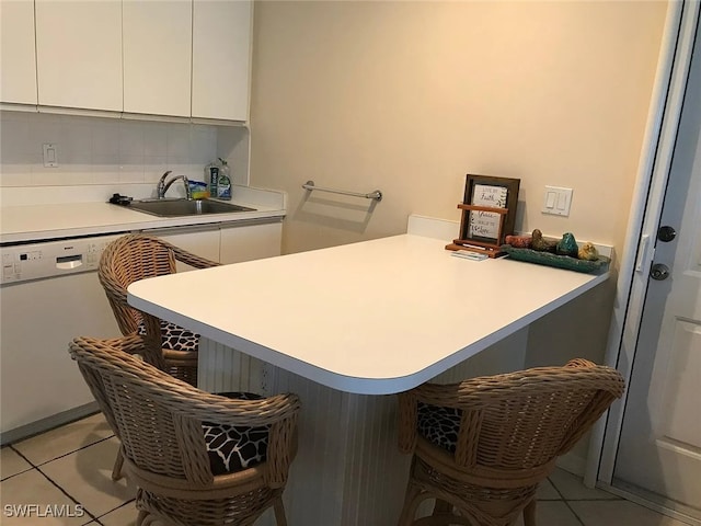 796 108th Ave N, Naples, FL 34108 - kitchen featuring white dishwasher, a breakfast bar, light tile patterned floors, and white cabinetry