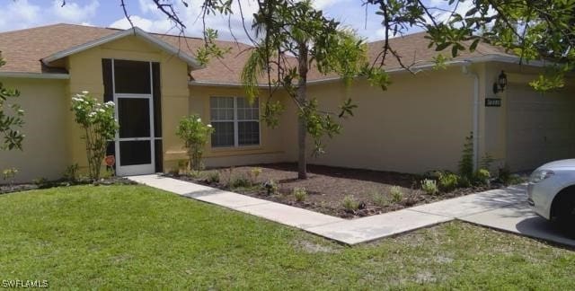15539 Horseshoe Ln, Fort Myers, FL 33905 - view of front of home featuring stucco siding, an attached garage, a front lawn, and concrete driveway