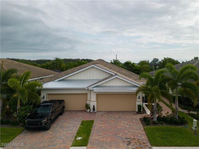 14727 Edgewater Cir, Naples, FL 34114 - ranch-style home featuring an attached garage and decorative driveway