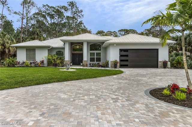 364 Logan Blvd S, Naples, FL 34119 - view of front of home with stucco siding, a garage, a front lawn, decorative driveway, and a metal roof