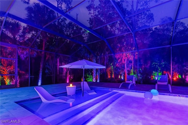 364 Logan Blvd S, Naples, FL 34119 - patio at night featuring glass enclosure, a patio area, and a deck