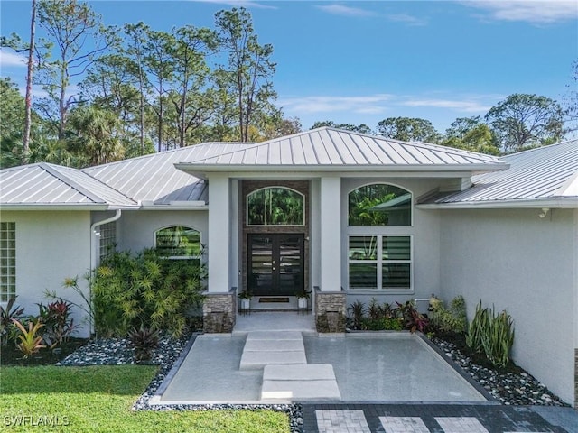 364 Logan Blvd S, Naples, FL 34119 - doorway to property featuring a standing seam roof, stucco siding, french doors, and a metal roof