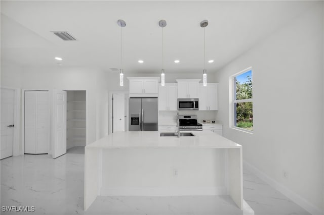 2605 28th St W, Lehigh Acres, FL 33971 - kitchen with stainless steel appliances, light marble finish floors, white cabinets, light countertops, and a center island with sink