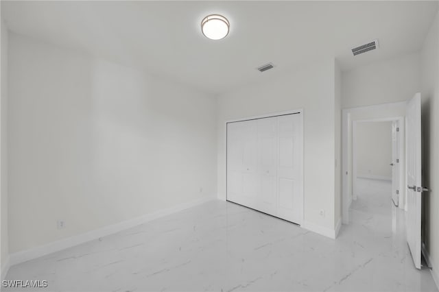 2605 28th St W, Lehigh Acres, FL 33971 - unfurnished bedroom featuring marble look tiles and a closet