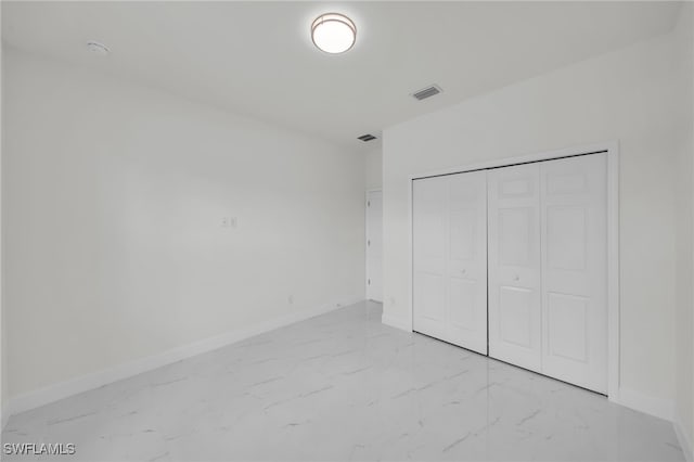 2605 28th St W, Lehigh Acres, FL 33971 - unfurnished bedroom featuring light marble finish flooring and a closet