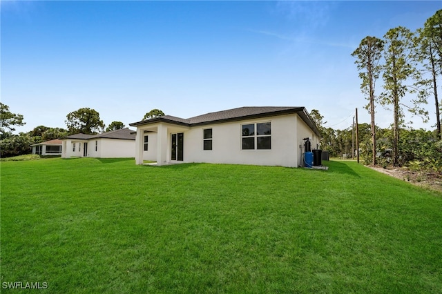 2605 28th St W, Lehigh Acres, FL 33971 - back of house with stucco siding and a lawn