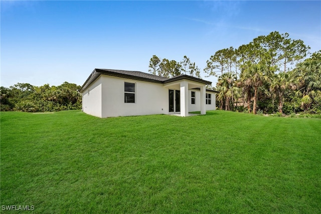2605 28th St W, Lehigh Acres, FL 33971 - rear view of house with a yard and stucco siding