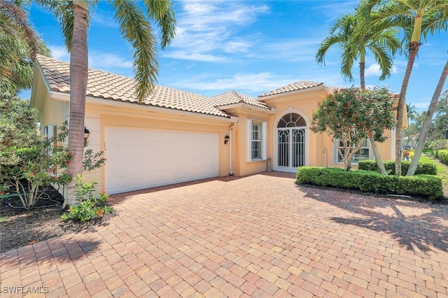 3008 Ellice Way, Naples, FL 34119 - mediterranean / spanish house with stucco siding, a garage, a tiled roof, and driveway
