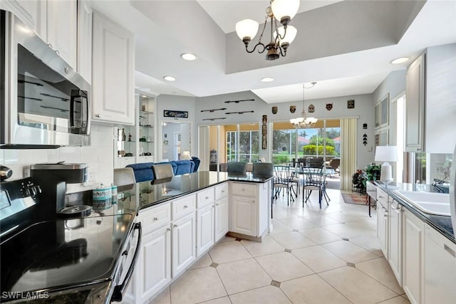 3008 Ellice Way, Naples, FL 34119 - kitchen featuring a chandelier, appliances with stainless steel finishes, a peninsula, dark countertops, and white cabinets