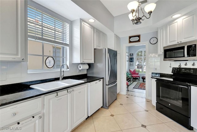 3008 Ellice Way, Naples, FL 34119 - kitchen featuring appliances with stainless steel finishes, white cabinets, a chandelier, and plenty of natural light