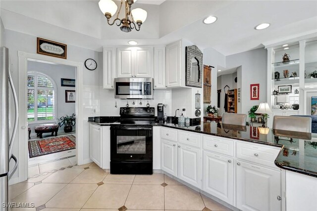 3008 Ellice Way, Naples, FL 34119 - kitchen with appliances with stainless steel finishes, white cabinets, dark stone counters, a chandelier, and a peninsula