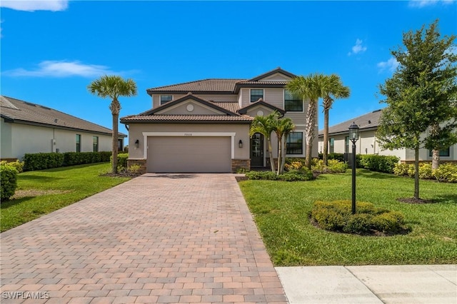 20028 Napa Loop, Estero, FL 33928 - mediterranean / spanish home featuring an attached garage, decorative driveway, stone siding, a tiled roof, and a front lawn