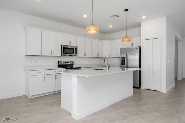 20028 Napa Loop, Estero, FL 33928 - kitchen with stainless steel appliances, white cabinetry, a center island with sink, light countertops, and hanging light fixtures