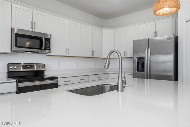 20028 Napa Loop, Estero, FL 33928 - kitchen with appliances with stainless steel finishes, light countertops, and white cabinetry