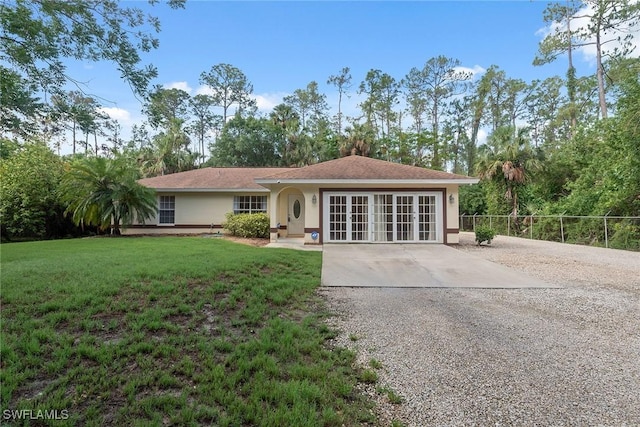 3210 2nd Ave SE, Naples, FL 34117 - single story home with french doors, gravel driveway, and stucco siding