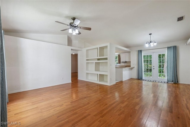 3210 2nd Ave SE, Naples, FL 34117 - unfurnished living room featuring lofted ceiling, light wood-style floors, ceiling fan, a chandelier, and french doors