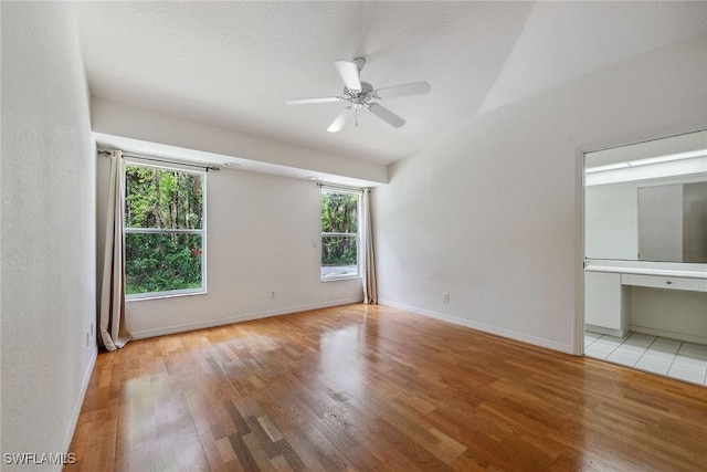 3210 2nd Ave SE, Naples, FL 34117 - unfurnished bedroom featuring wood finished floors, vaulted ceiling, a ceiling fan, and connected bathroom