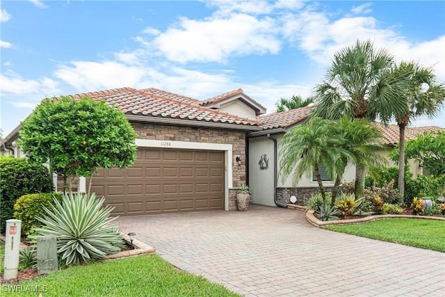 11288 Red Bluff Ln, Fort Myers, FL 33912 - mediterranean / spanish-style home featuring stone siding, a garage, driveway, a tiled roof, and stucco siding