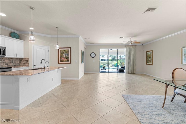 11288 Red Bluff Ln, Fort Myers, FL 33912 - kitchen with stainless steel microwave, backsplash, light tile patterned floors, crown molding, and a ceiling fan