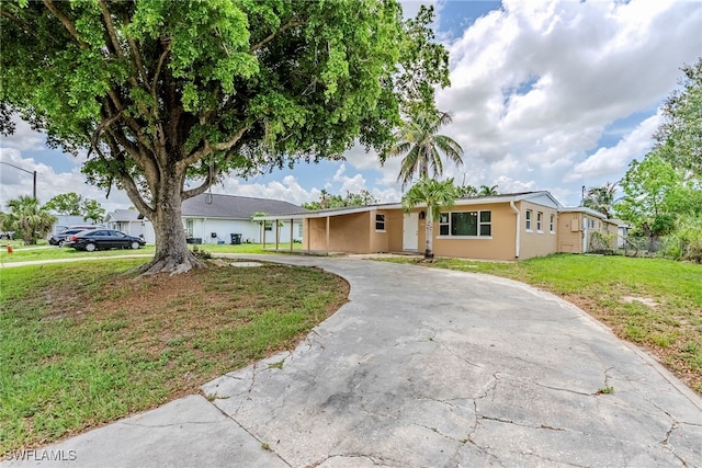 2414 Braman Ave, Fort Myers, FL 33901 - ranch-style house featuring curved driveway, a front lawn, and stucco siding