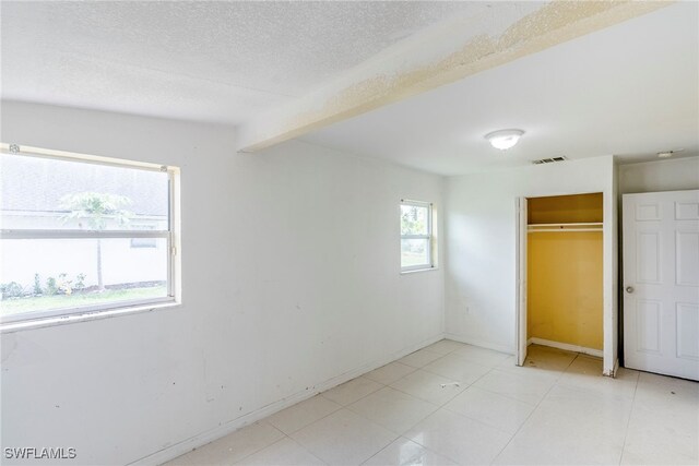 2414 Braman Ave, Fort Myers, FL 33901 - unfurnished bedroom with beamed ceiling, a closet, and a textured ceiling