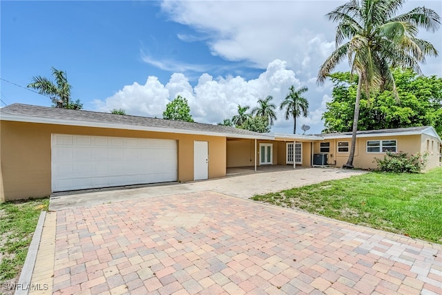2414 Braman Ave, Fort Myers, FL 33901 - ranch-style home with stucco siding, decorative driveway, a front lawn, and an attached garage