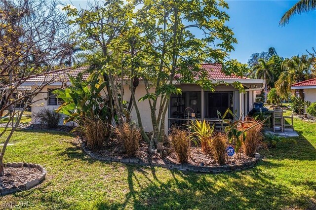 7208 Saint Anns Ct, Fort Myers, FL 33908 - rear view of property featuring a lawn, stucco siding, and a tiled roof
