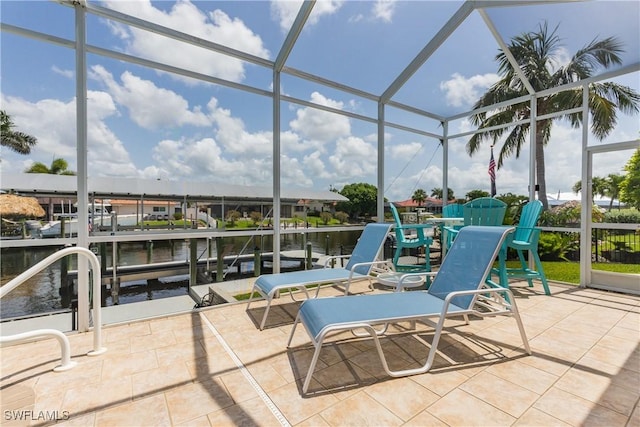1221 SW 53rd Ter, Cape Coral, FL 33914 - view of patio / terrace with glass enclosure, a dock, a water view, and boat lift
